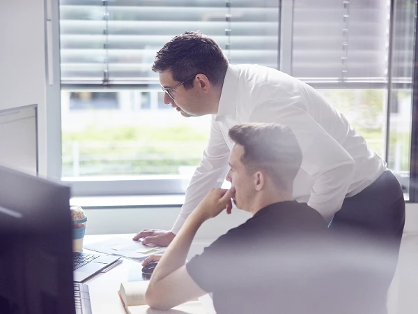 Zwei Kollegen arbeiten gemeinsam am Computer