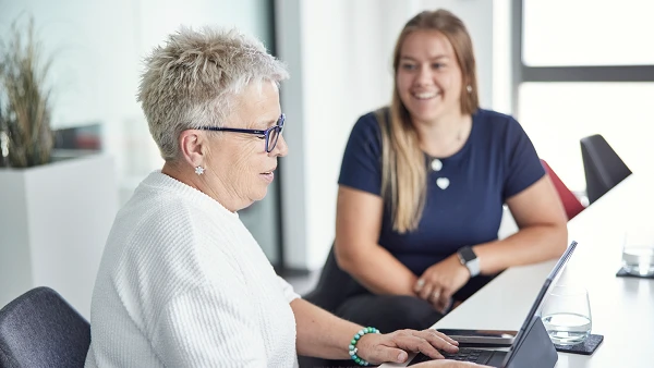 Zwei Afileon-Mitarbeiterinnen im Gespräch an einem Bürotisch