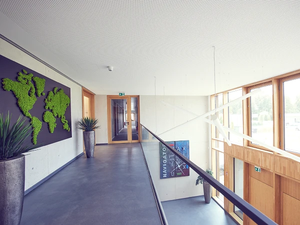 Büroflur mit Weltkarte aus Moos und großflächigen Fenstern
