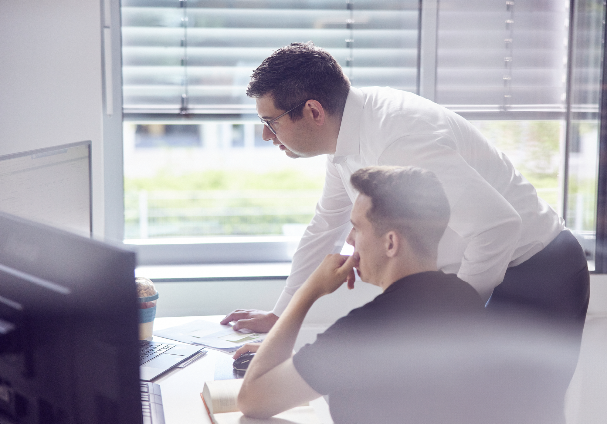 Zwei Kollegen arbeiten gemeinsam am Computer