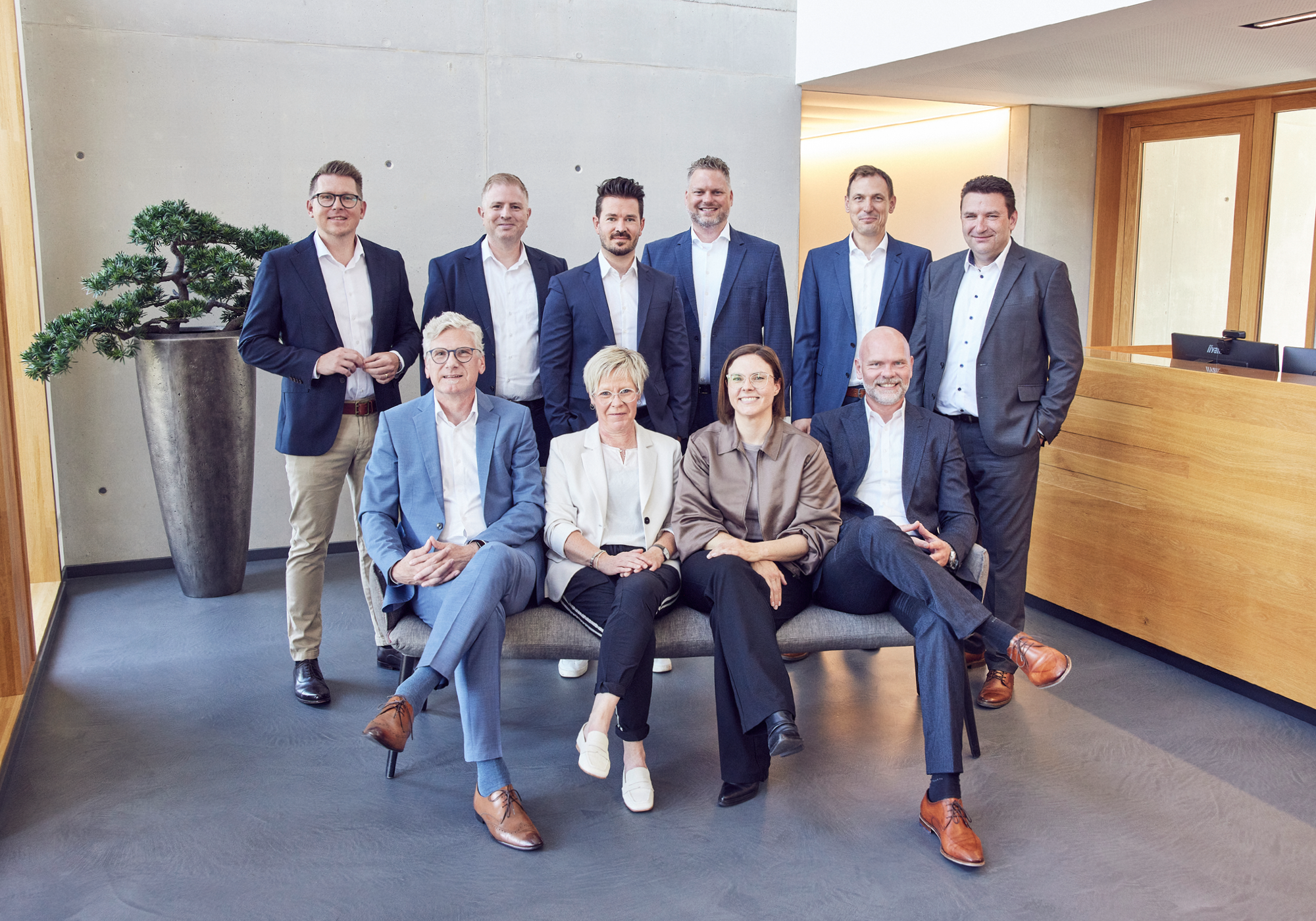 Gruppe von zehn Afileon-Teammitgliedern im Foyer