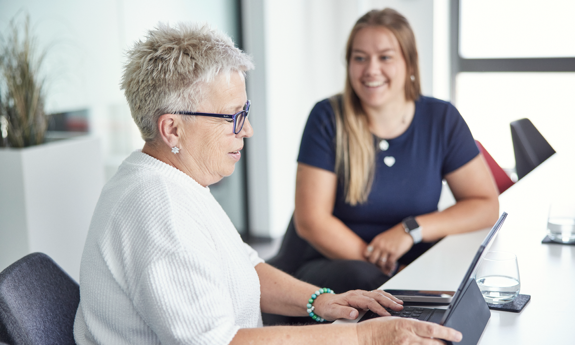 Zwei Afileon-Mitarbeiterinnen im Gespräch an einem Bürotisch