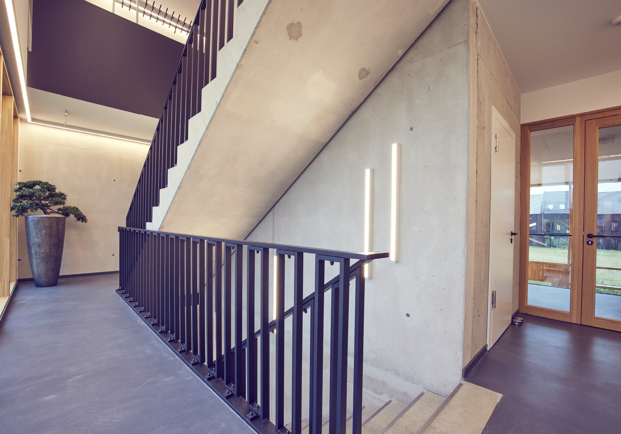 Innenansicht eines modernen Treppenhauses mit Betonwänden und Pflanzen