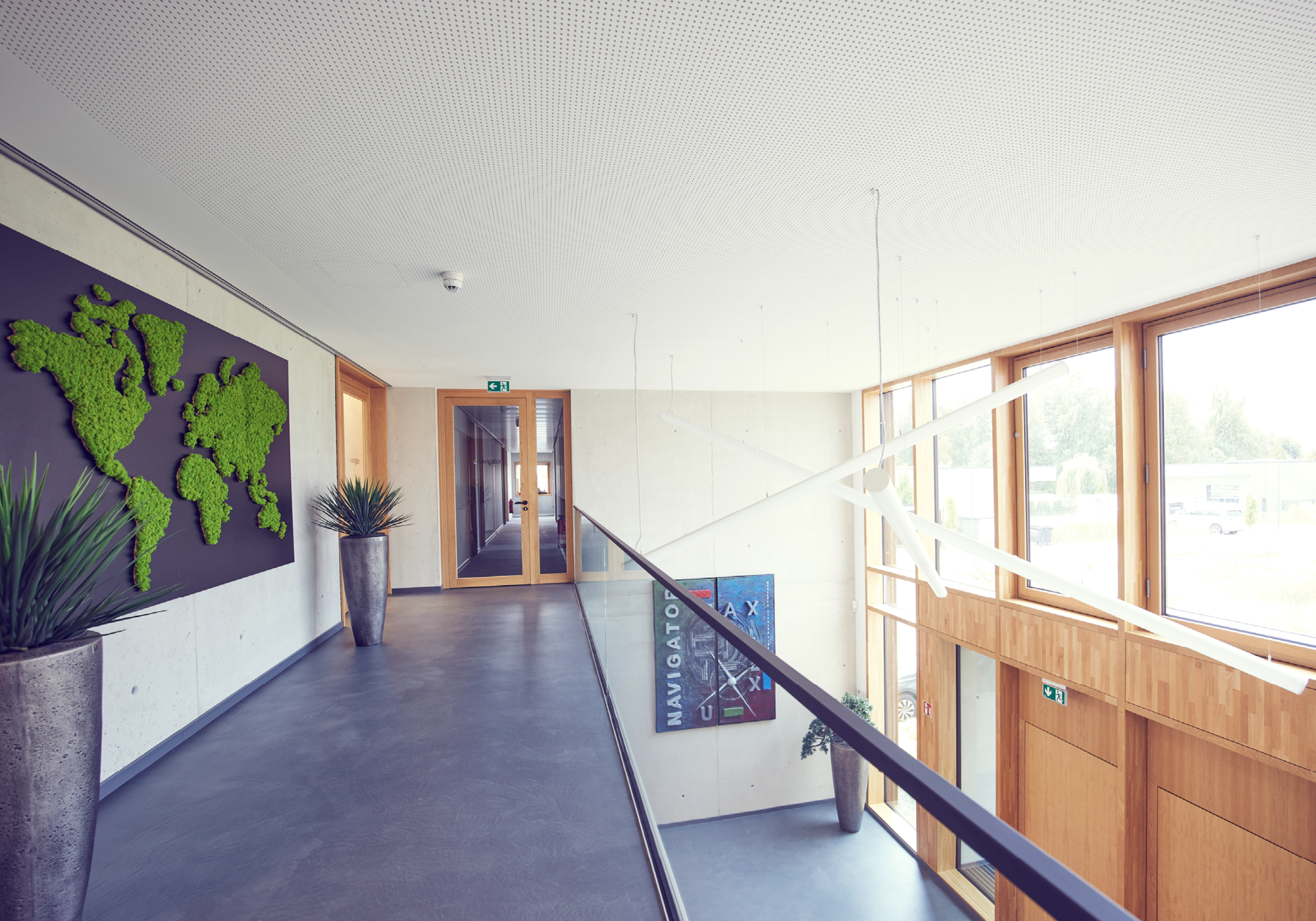 Büroflur mit Weltkarte aus Moos und großflächigen Fenstern