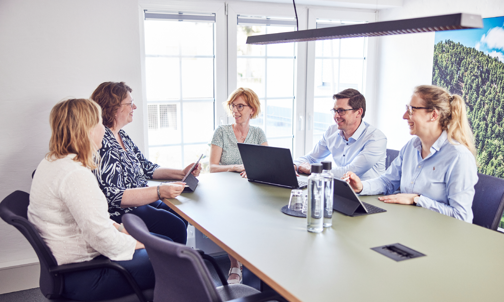 Besprechung von fünf Teammitgliedern in einem Konferenzraum